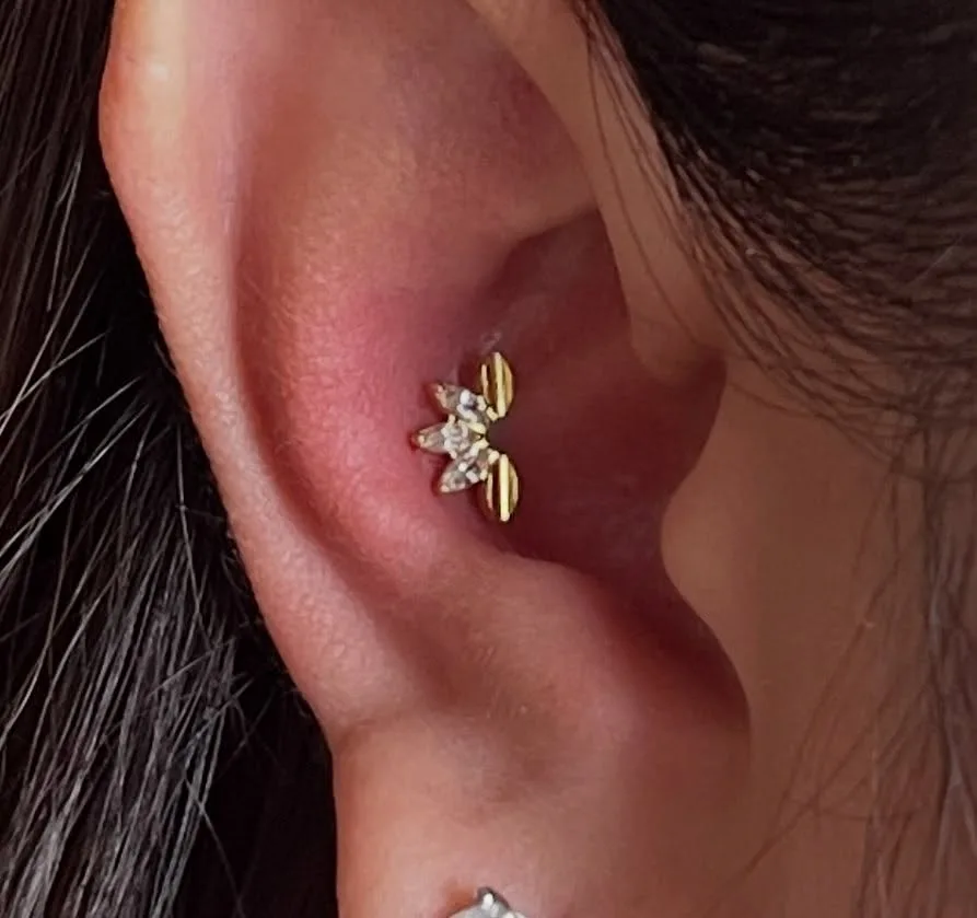 Gold flower stud with crystal and leaf petals on the antihelix