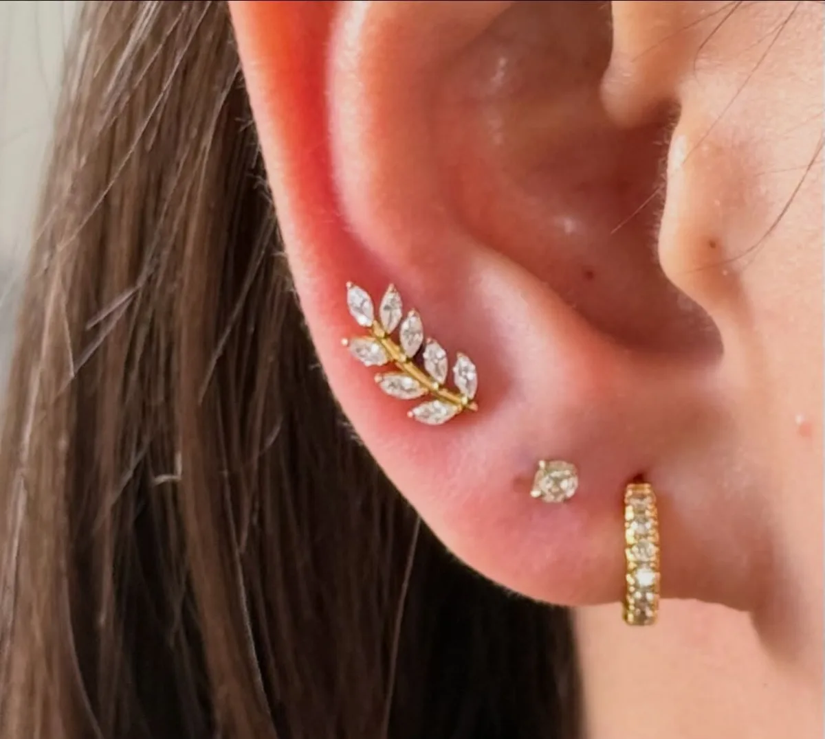 Curated lobe stack with a gold crystal leaf climber, solitaire stud, and gold pave huggie hoop